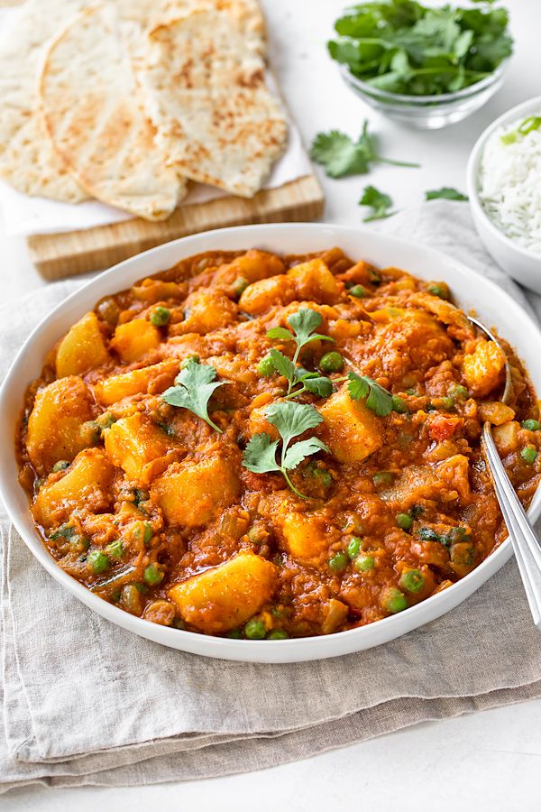 a white bowl filled with food next to bread