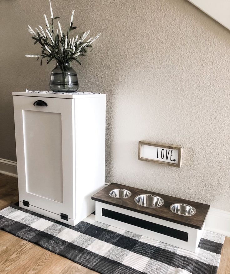 a dog house with two bowls and a sign on the wall next to it that says love