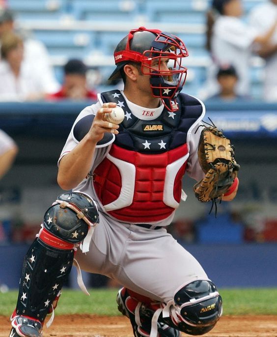 a baseball player holding a catchers mitt in his right hand and ready to catch the ball