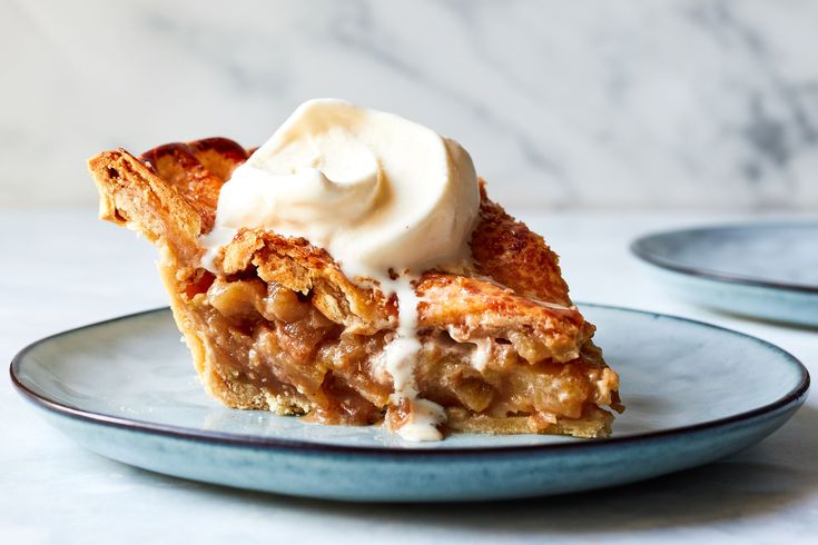 a piece of pie with whipped cream on top is sitting on a blue and white plate