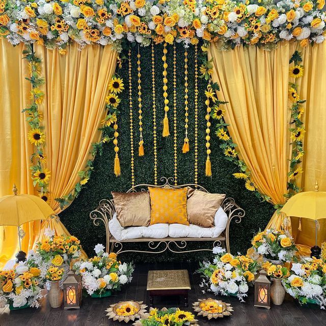 a decorated stage with yellow drapes and sunflowers