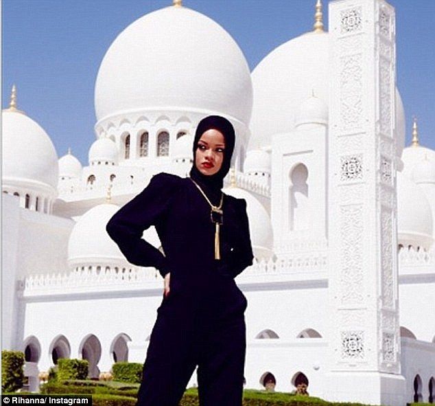 a woman standing in front of a large white building with domes on it's sides