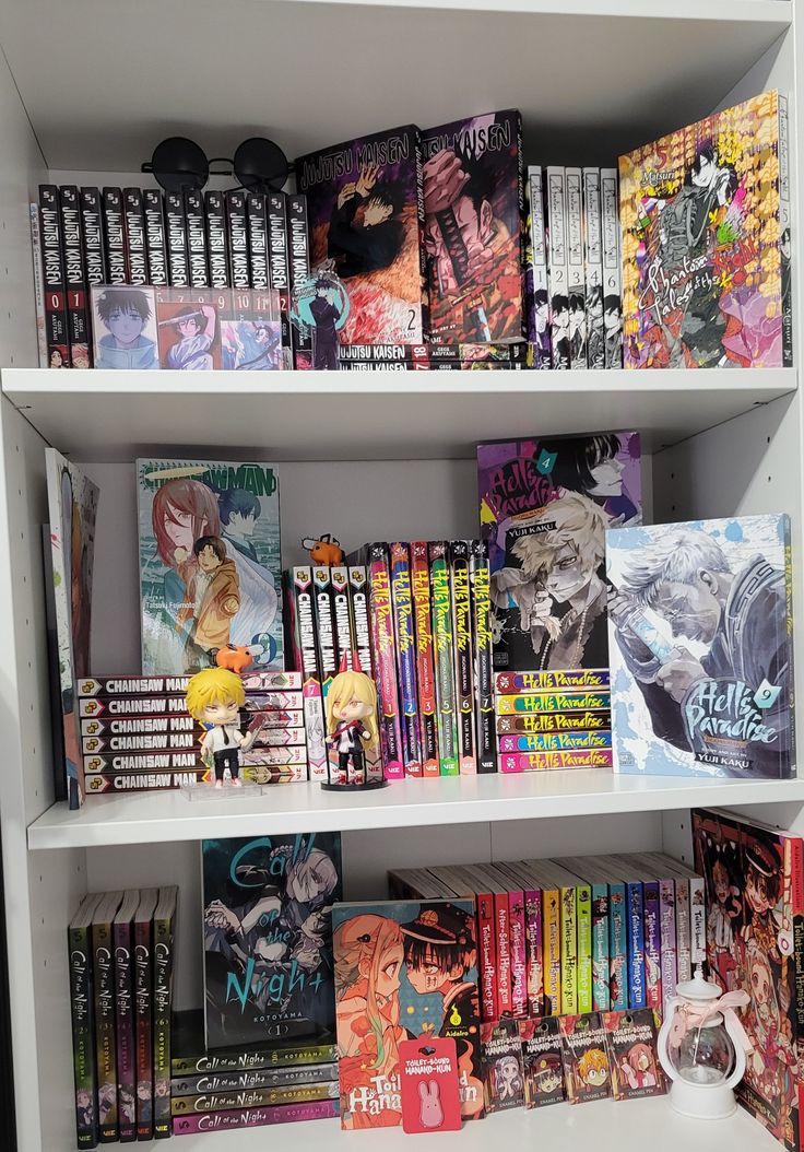 a book shelf filled with lots of books on top of white shelving unit shelves