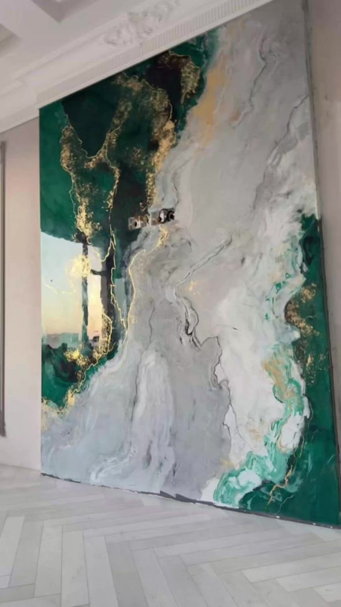 an abstract painting on the wall with white and green paint, in a large room