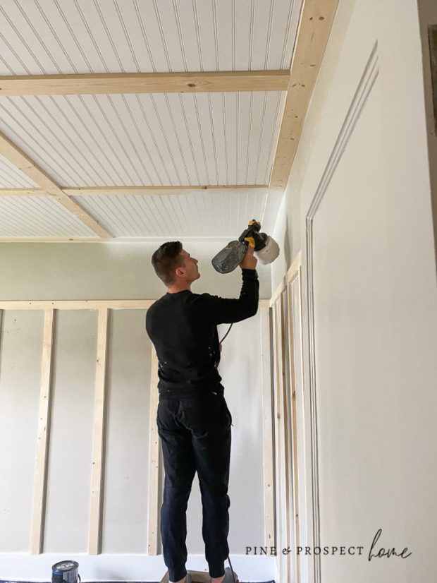 a man is painting the ceiling in his house