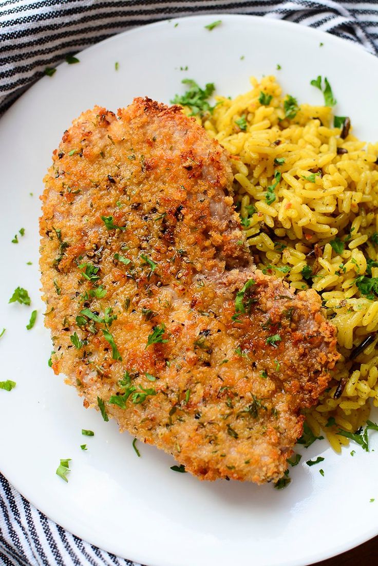 a white plate topped with meat and rice