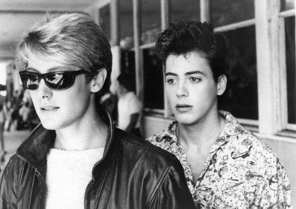 two young men wearing sunglasses standing next to each other