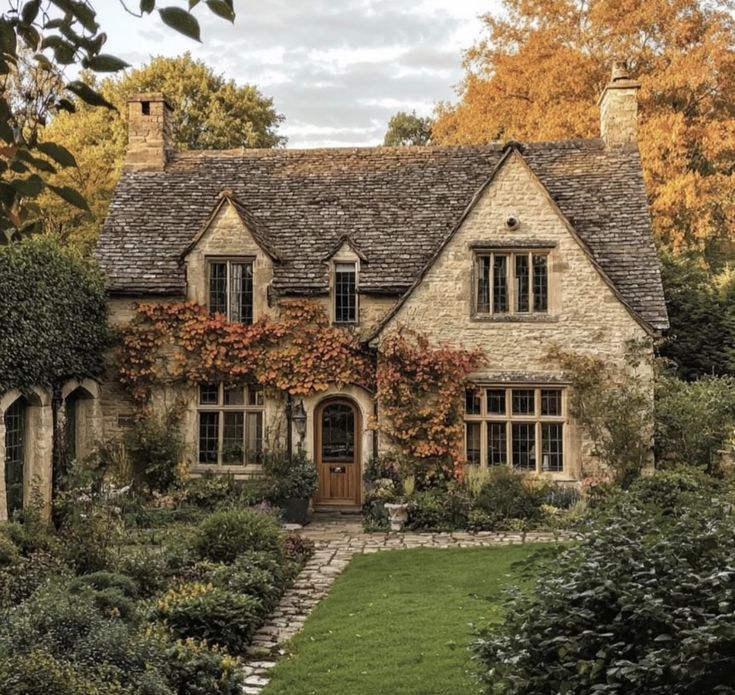 a stone house surrounded by trees and bushes