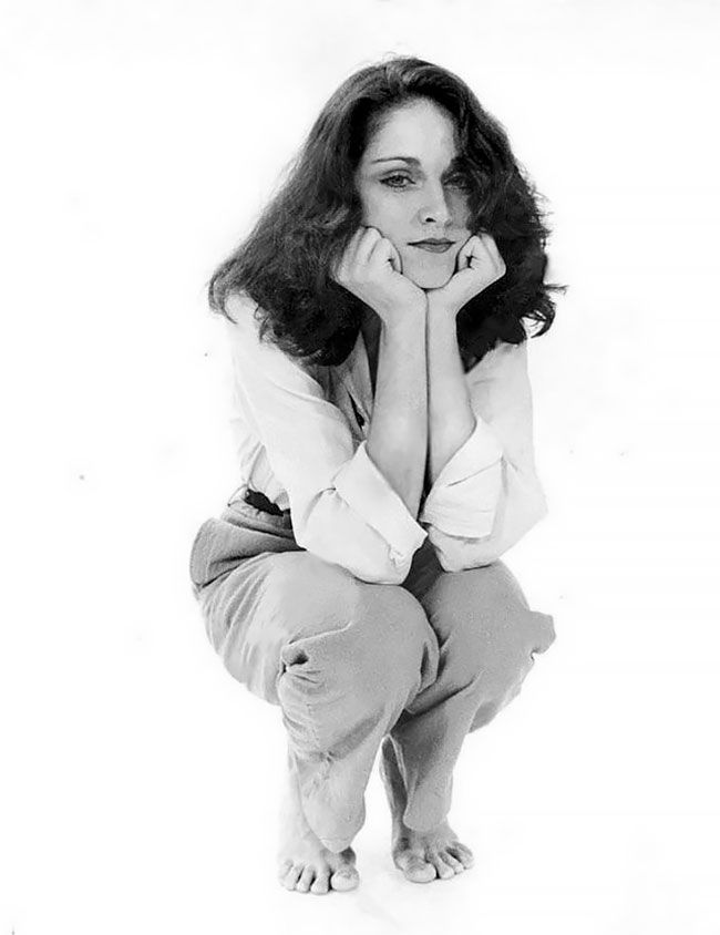 black and white photograph of a woman posing with her hands on her chins,