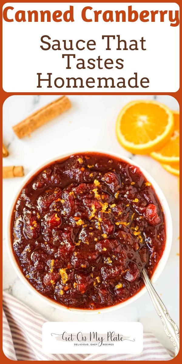 a white bowl filled with cranberry sauce next to orange slices and cinnamon sticks