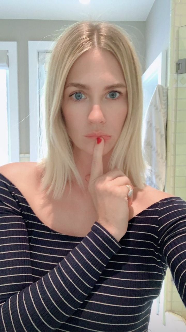 a woman is taking a selfie with her finger on her lips and looking at the camera