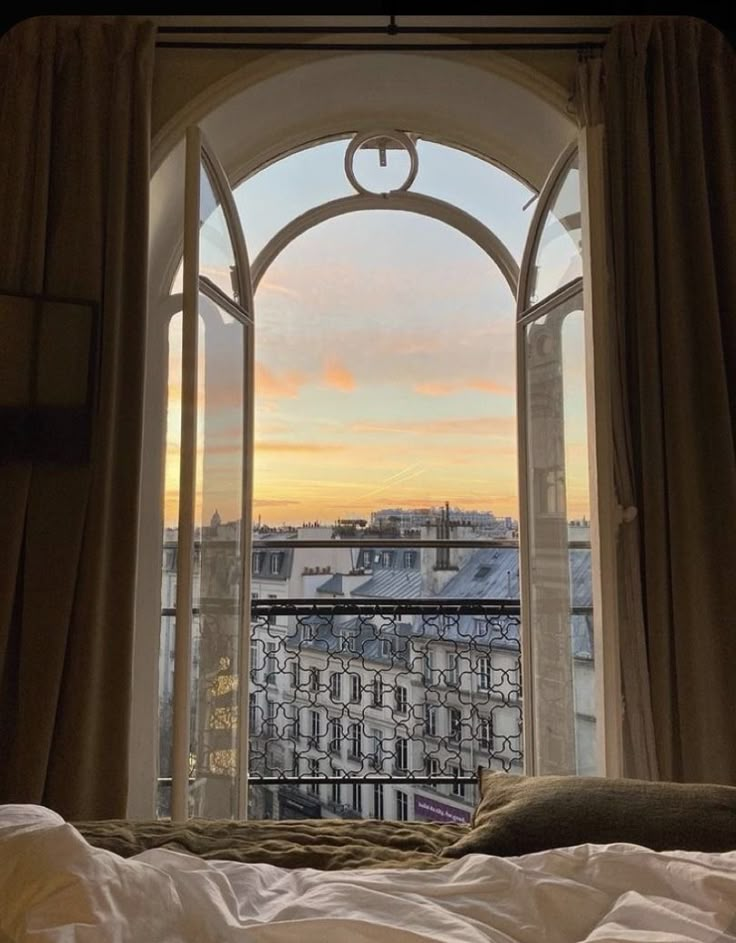 an open window overlooking the city at sunset