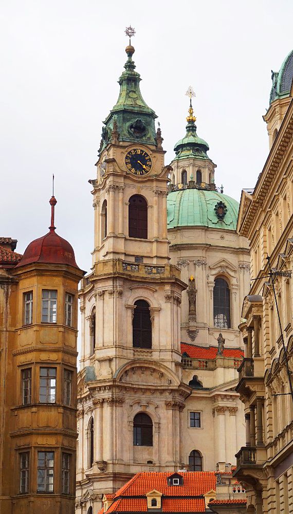 an old building with two towers and a clock on it's side in the city