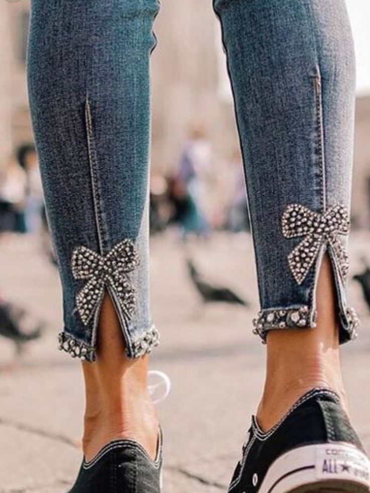 a woman's feet with bows and pearls on them, standing in front of pigeons