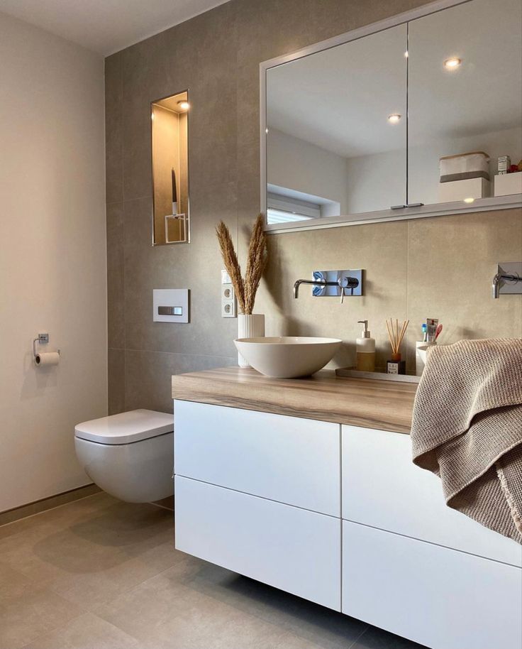 a bathroom with a toilet, sink and mirror in it's centerpieces