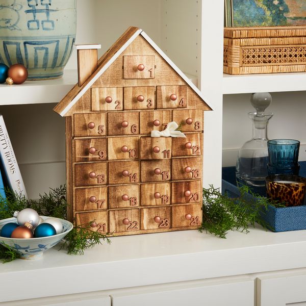 a wooden house shaped like a mailbox on top of a shelf next to other items