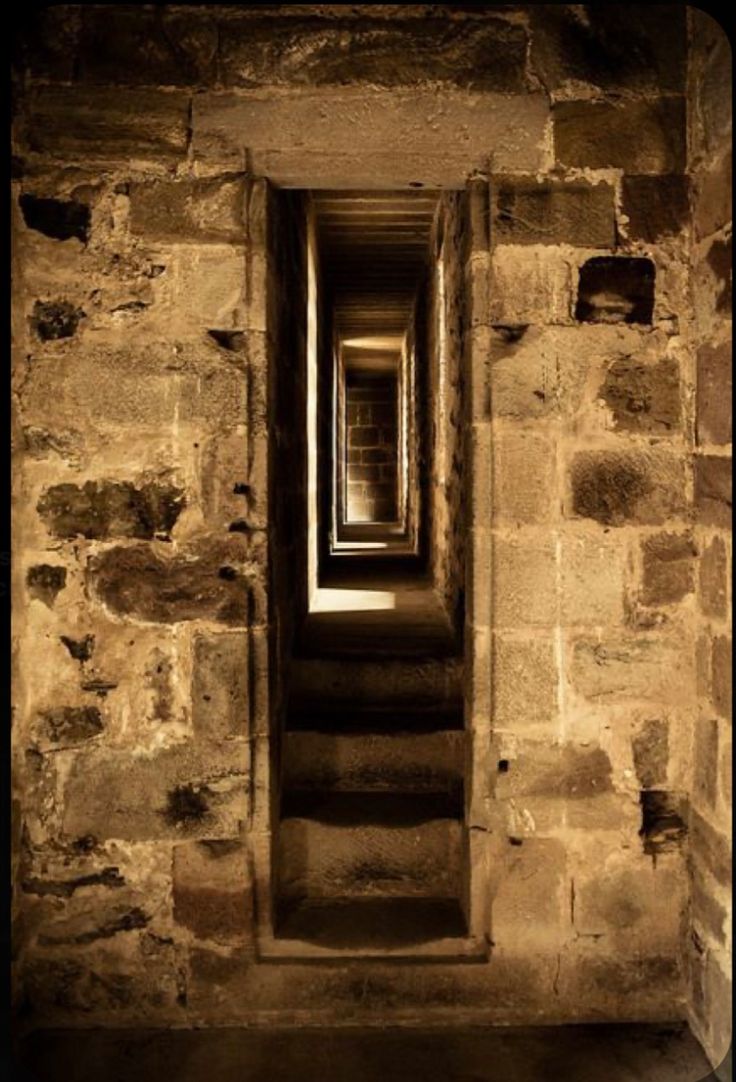 an open door leading to another room in a stone building with light coming through it