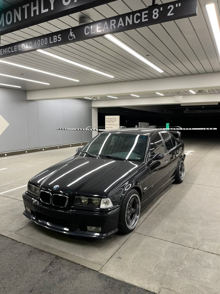 a black car parked in an empty parking garage