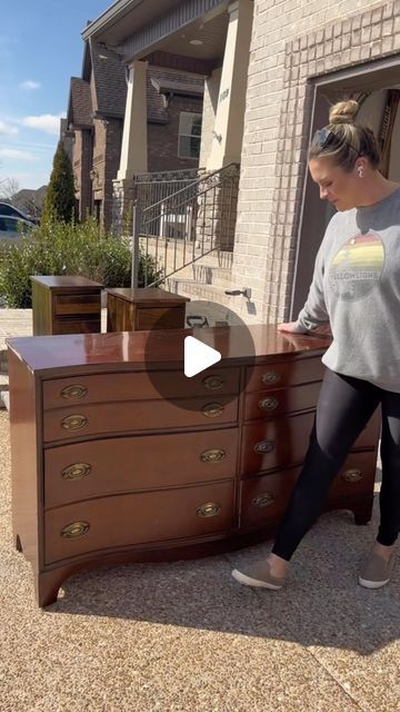 a woman standing next to a dresser in front of a house