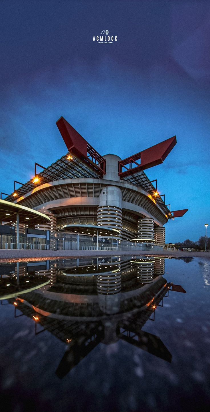 the building is reflecting in the water at night