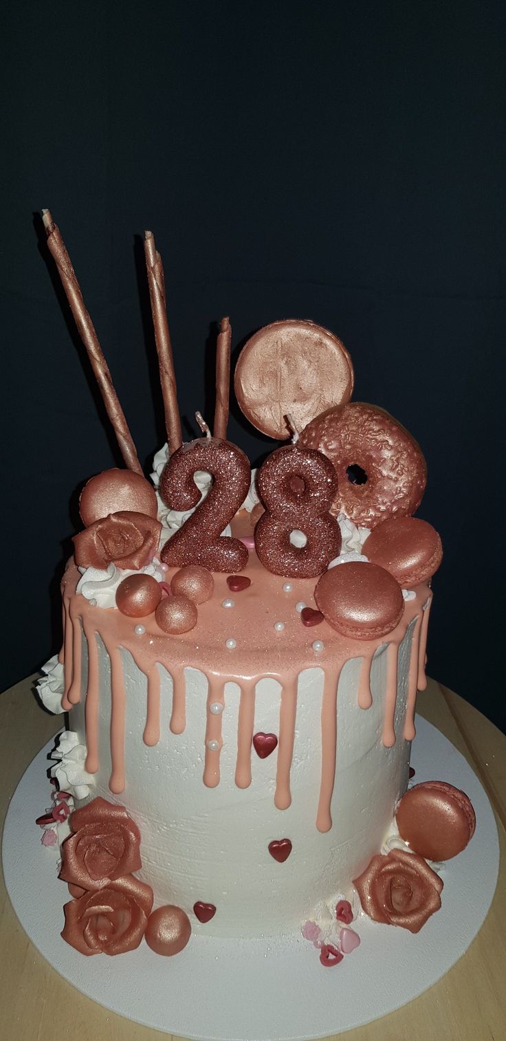 there is a cake with donuts and candles on the top it has pink icing