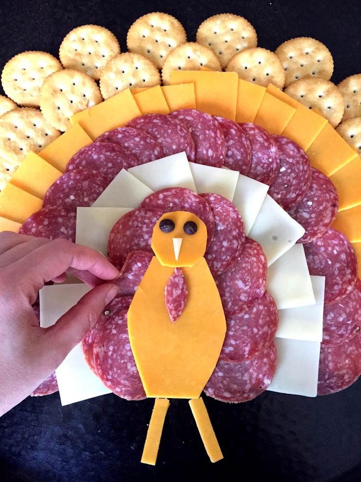 a turkey shaped cheese and meat platter with crackers in the shape of cookies