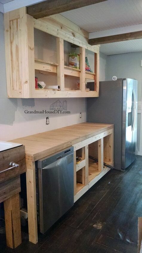 an unfinished kitchen with wooden cabinets and stainless steel appliances in the middle of the room