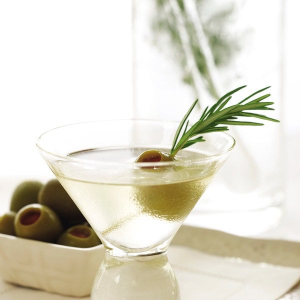 an olive martini is garnished with rosemary