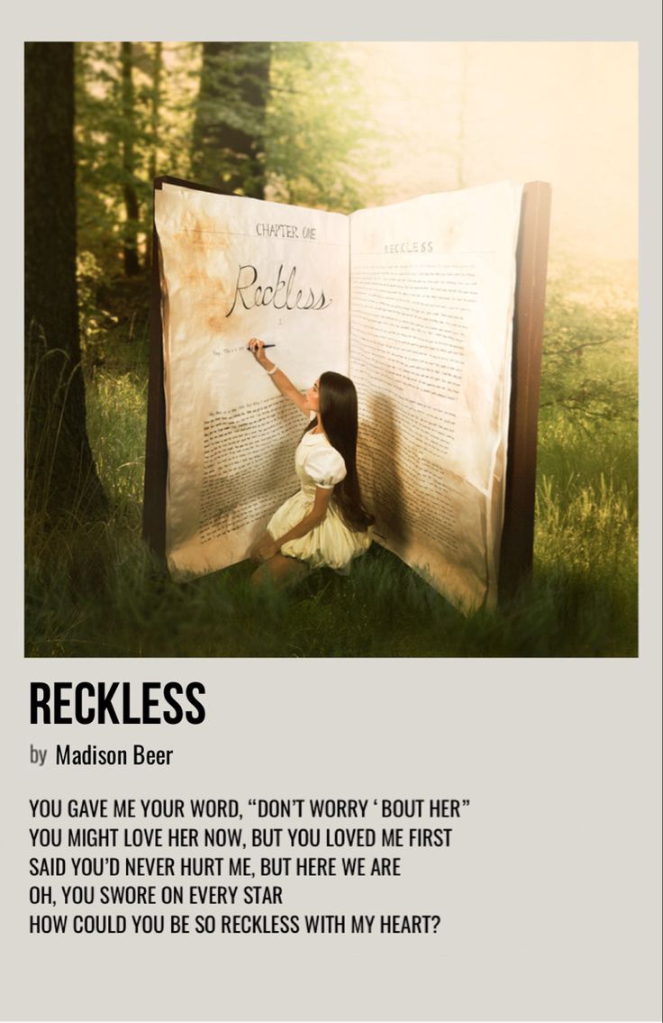 a woman sitting in the grass reading a book with an open page that reads reckless