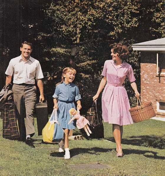 a man, woman and child are walking in the grass