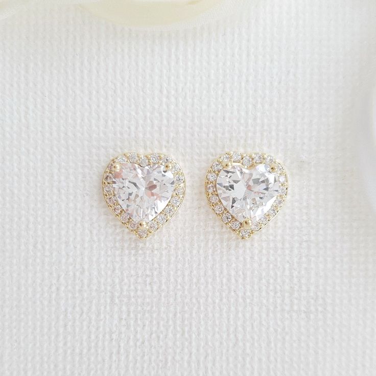 14K Gold Plated Cubic Zirconia Heart Stud Earrings for Weddings & Events These pretty 14k gold cubic zirconia heart earrings studs are sparkly for weddings and events. These pretty heart earrings are great for bridesmaids, brides, and any women looking for simple and heart-shaped sparkling earrings. These are made with high-grade cubic zirconia; you can use them for long periods, on every occasion after the wedding. The CZ heart-shaped gold earrings are available in two other finishes gold, silv Rose Gold Bridesmaid Jewelry, Gold Bridesmaid Jewelry, Minimalistic Earrings, Poetry Design, Rose Gold Heart Necklace, Gold Heart Stud Earrings, Heart Jewelry Set, Wedding Earrings Studs, Hearts Earrings