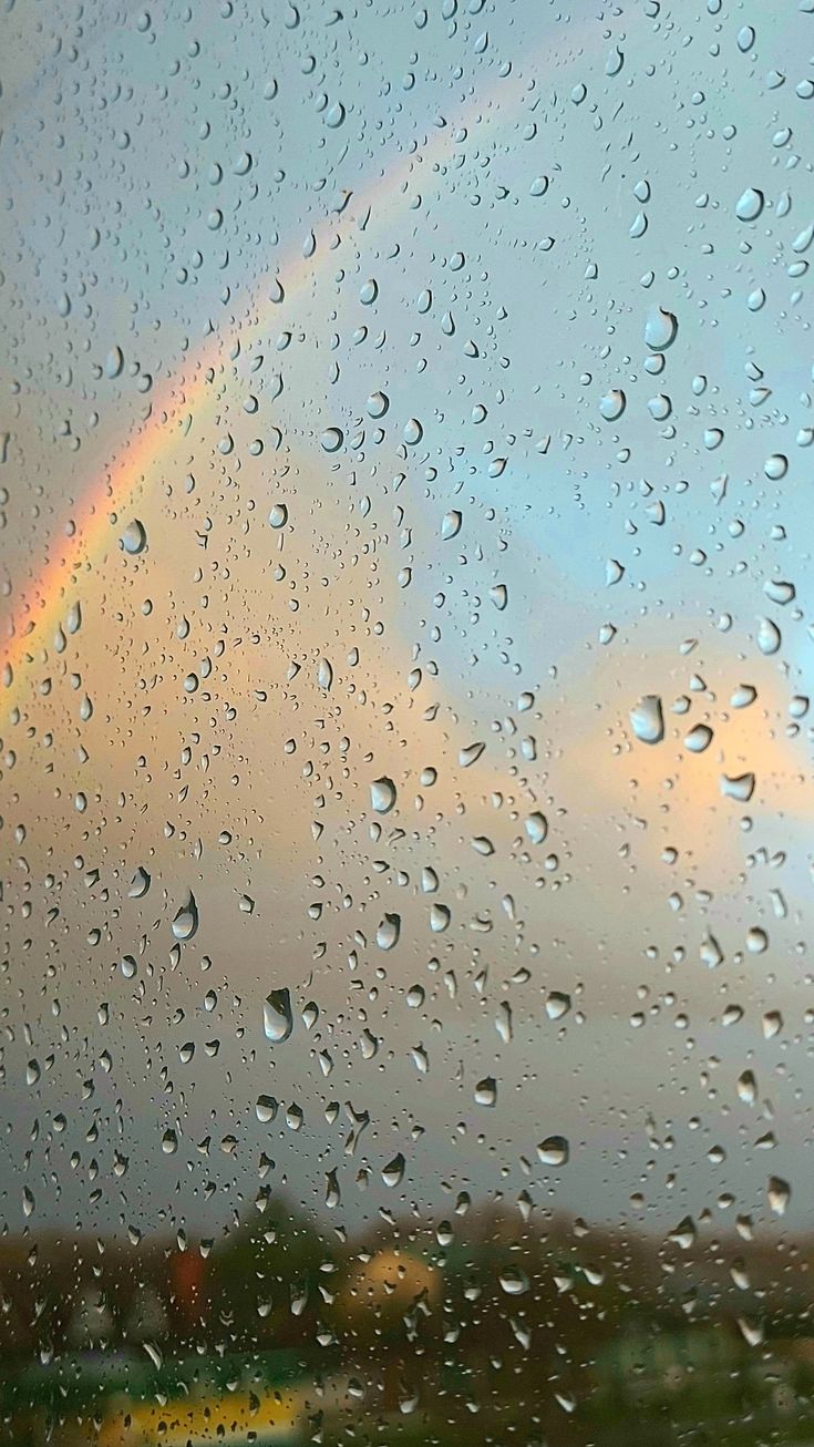 rain drops on the window with a rainbow in the background