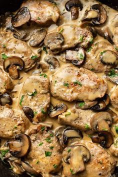 a skillet with chicken and mushrooms covered in gravy