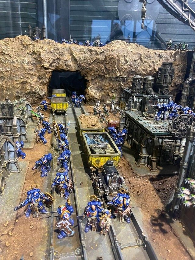 a group of toy soldiers are on the tracks in front of a train track tunnel