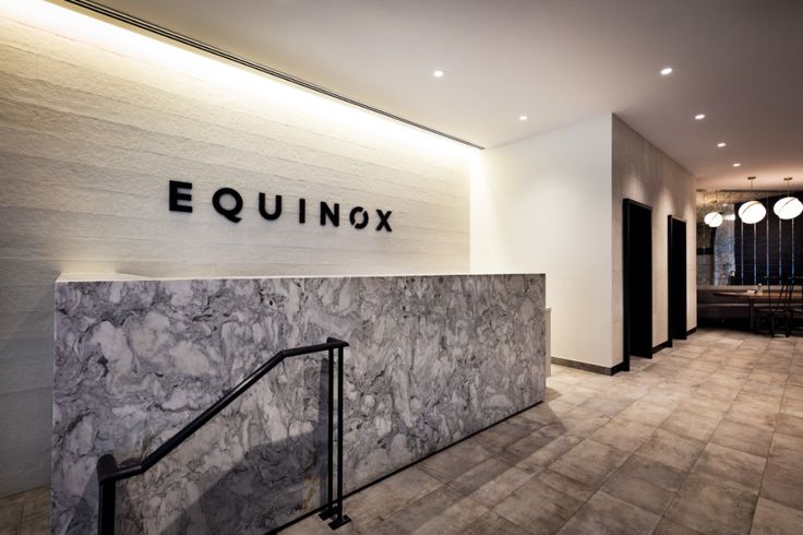 the entrance to equinox's office building with marble walls and flooring