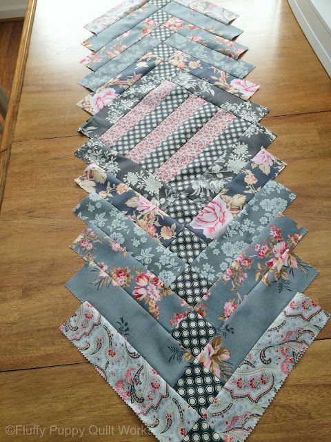 several pieces of fabric laid out on the floor to make a quilted table runner