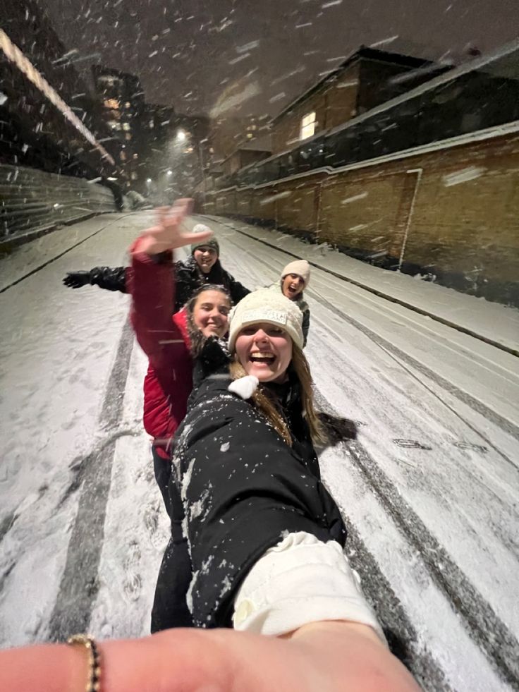 three people taking a selfie in the snow with one person holding out their hand