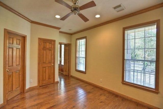 an empty living room with wood floors and ceiling fan in it's center area