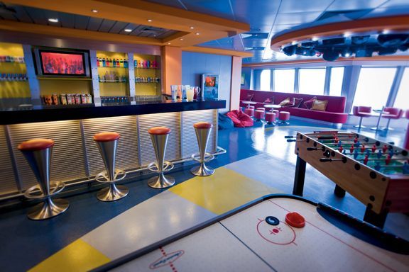 an indoor game room with foo - pong tables and bar stools