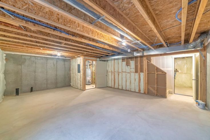 an empty room with unfinished walls and wood beams on the ceiling is seen in this image