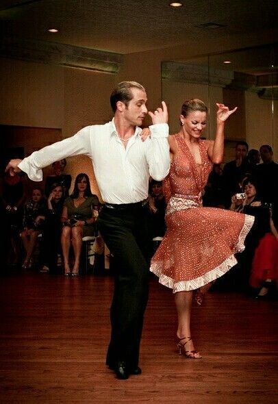 a man and woman are dancing on the dance floor