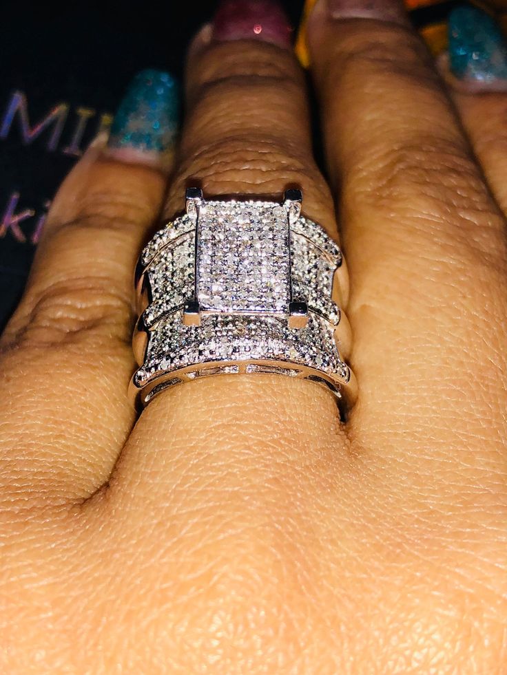 a woman's hand with two wedding rings on her left and the other one is wearing a diamond ring