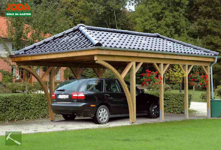 a car is parked under a wooden shelter