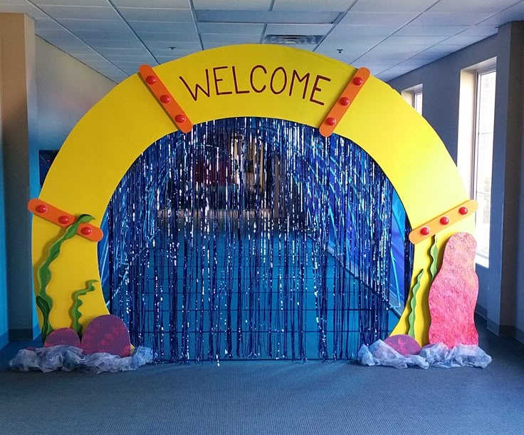 an entrance to a school with blue and yellow decorations on the front, and welcome sign at the back