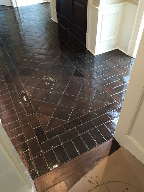 an empty bathroom with black tile flooring and white walls