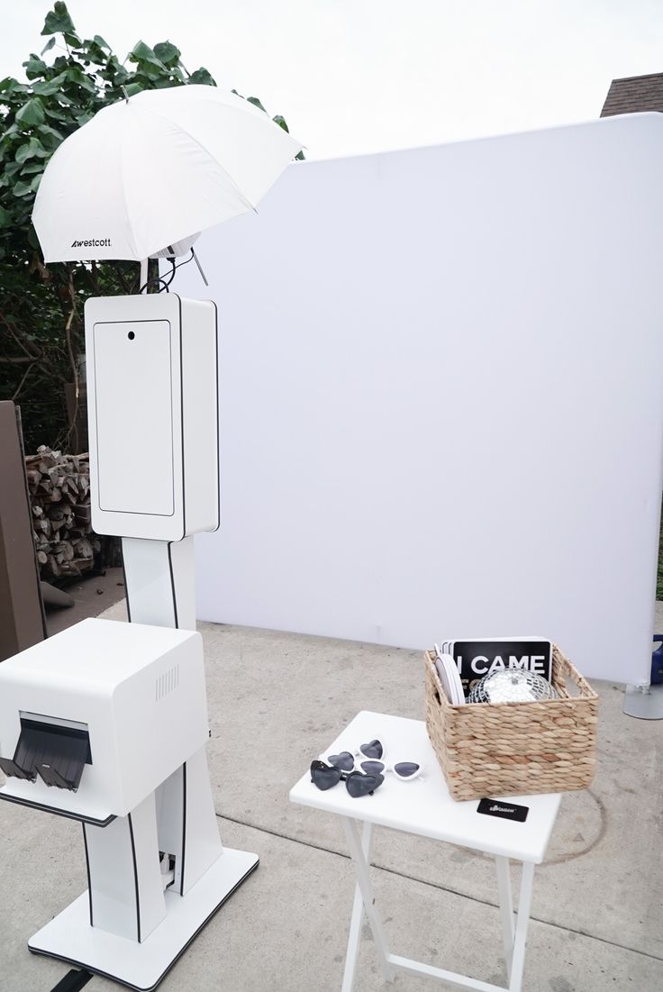 a white table with an umbrella on top of it next to a box and other items