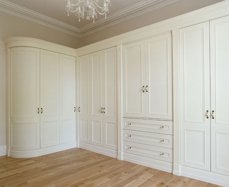 an empty room with white closets and chandelier hanging from the ceiling,