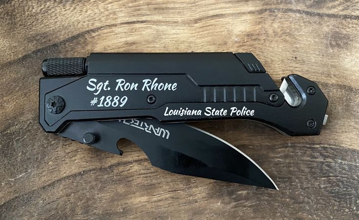 a knife that is sitting on top of a wooden table with the name st louis r rowe