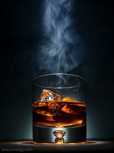 a glass filled with liquid and ice on top of a table