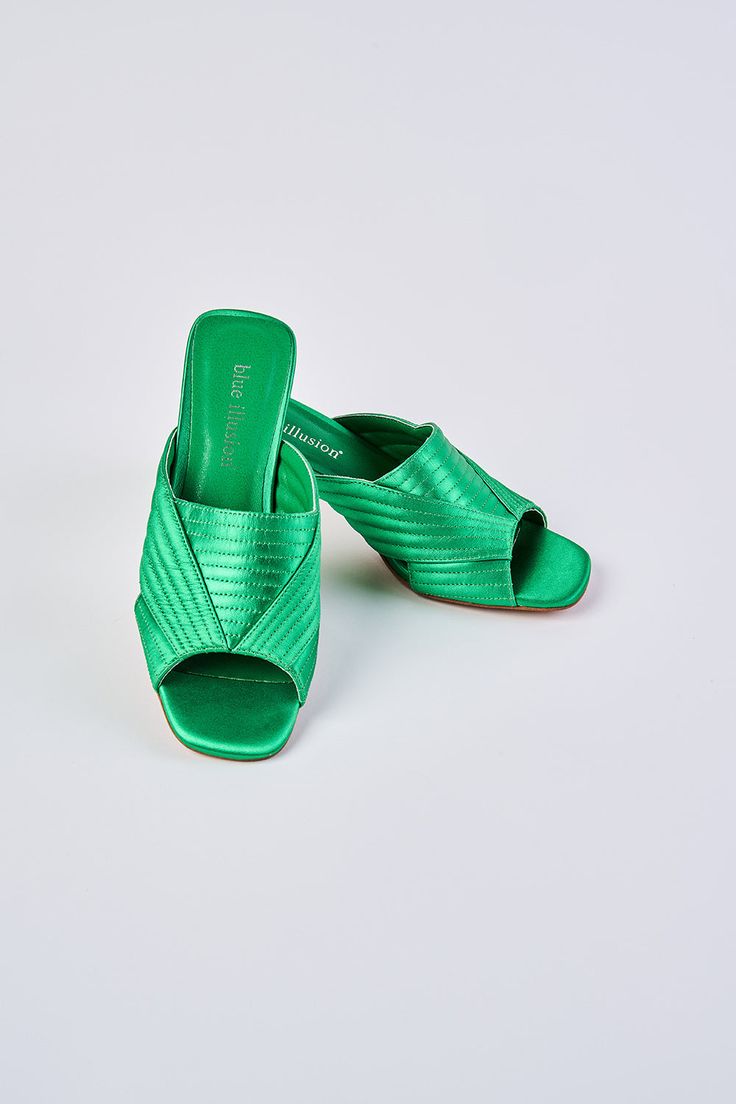 Ultra-chic, ultra-comfortable, introducing our Stella Satin Mule. Crafted from satin in brilliant metallic Green, this shoe features a trendy triangular shaped heel in a tonal shade of green. We love the chic cut-out crossover design and square-shaped peep toe. Complete your look with this bold pop of colour. Green Heels With Removable Insole And Pointed Toe, Green Heels With Padded Heel For Spring, Summer Satin Sandals With Pointed Toe, Green Spring Heels With Padded Heel, Green Pointed Toe Sandals With Removable Insole, Spring Green Heels With Padded Heel, Modern Green Heels With Wrapped Heel, Green Block Heel With Removable Insole, Green Slip-on Sandals For Party